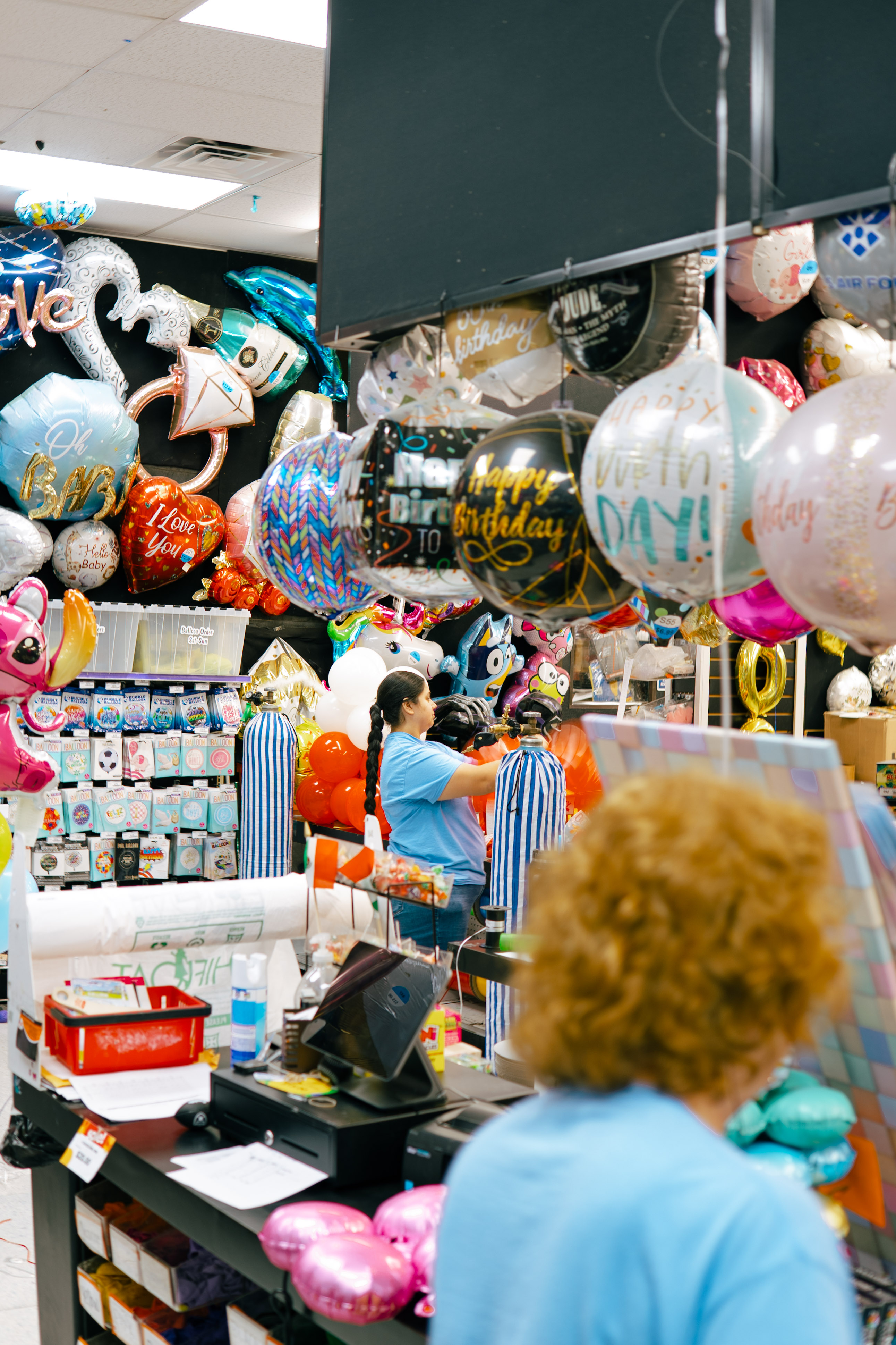 PartyWorks customer service counter with staff consultations and mylar balloons